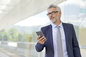 Reifer Mitarbeiter geht über sein Handy auf eine Active Sourcing Anfrage ein