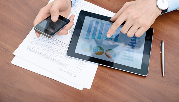 Compliant Sourcing Tablet und Papiere liegen vor einem Mitarbeitenden auf dem Tisch