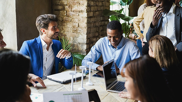 10 Mitarbeitende sitzen bei einem Meeting zusammen
