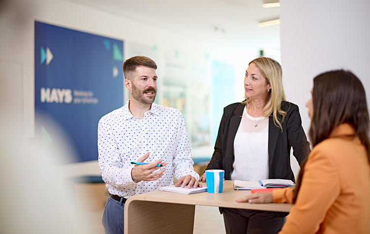 Colleague discusses with two female colleagues