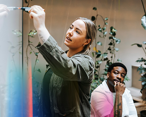 Colleagues working with markers on a whiteboard