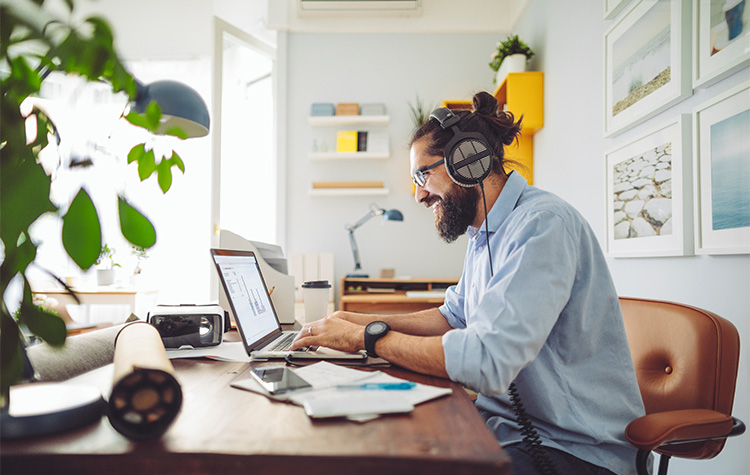 Hays Job Alert aktivieren Frau in Business-Kleidung beugt sich lächelnd über einen geöffneten Laptop