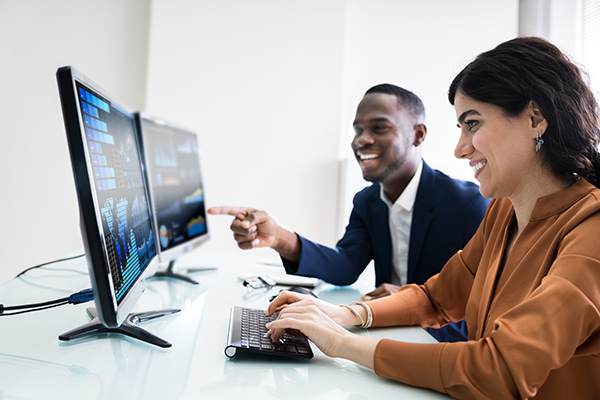Zwei Kollegen schauen auf Monitore
