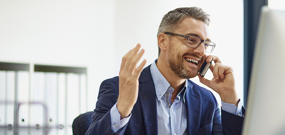 Valuable recruiting tips for remote managing Man in suit makes a joyful phone call