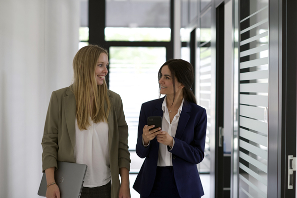 Frauen unterhalten sich gehend im Büro