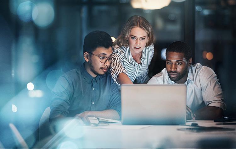 Drei SAP Kollegen stehen um Laptop herum