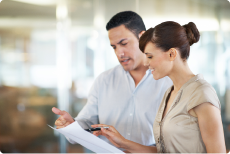 Two employees look at a document together