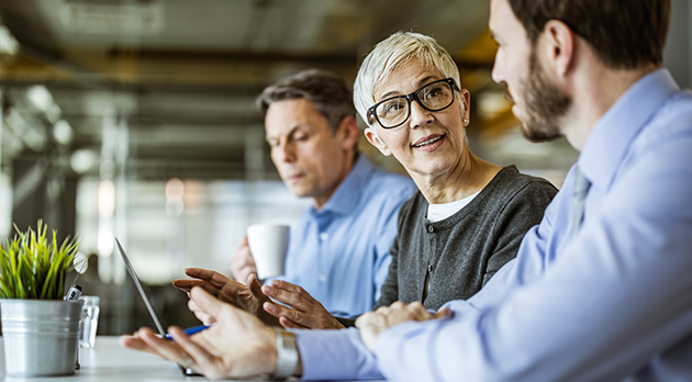 Drei Kollegen sitzen am Tisch und trinken