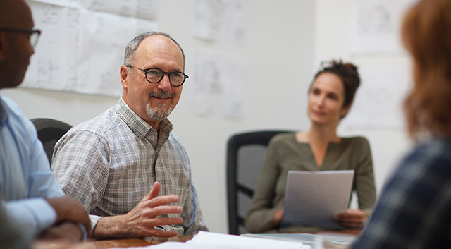 Vier Kollegen sitzen am Tisch